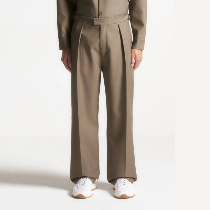 Model wearing khaki pleated tailored trousers.